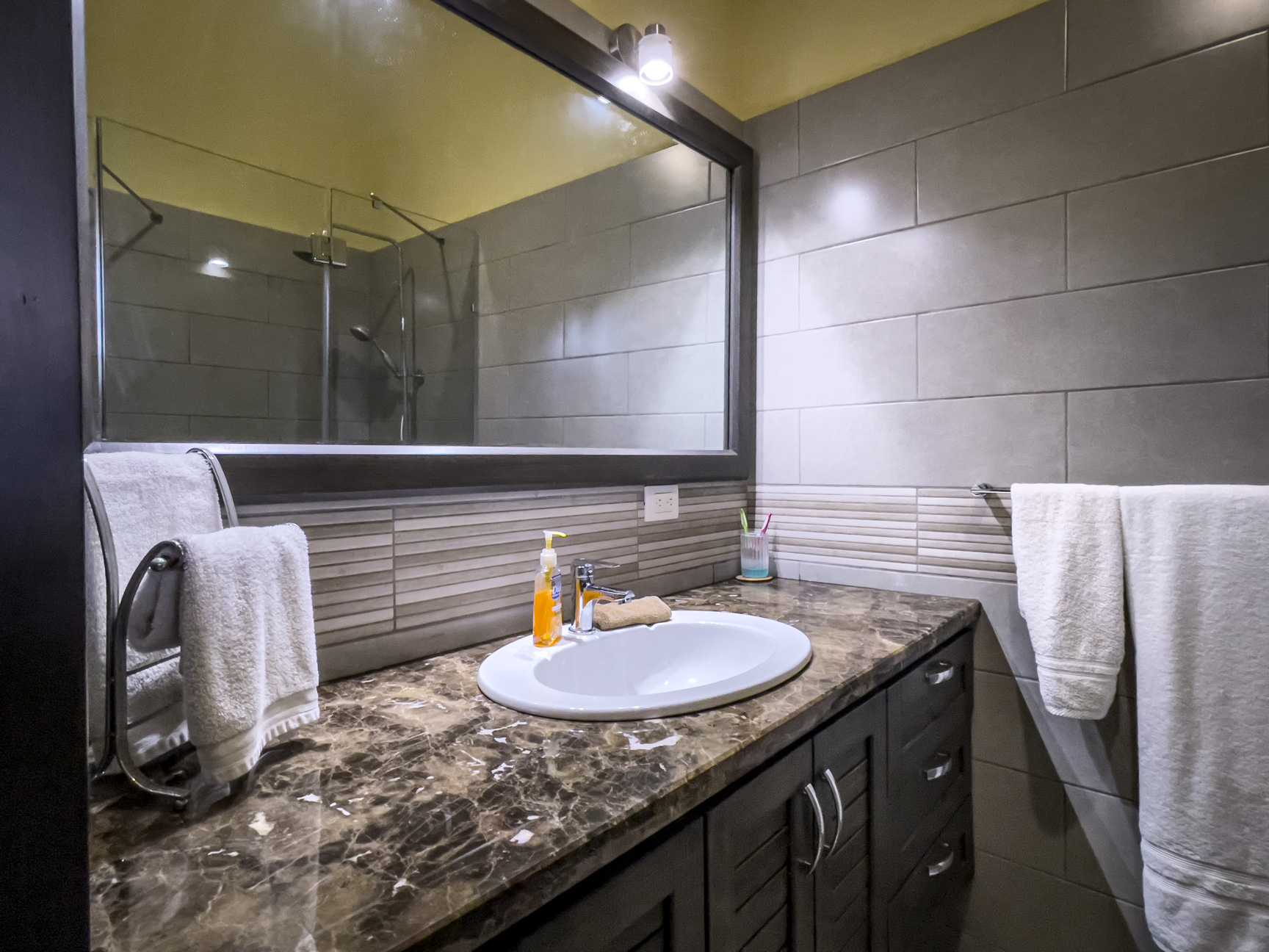 buyDRproperty Bathroom vanity with oval sink and mirror in a stunning 2 bedroom villa. Sosua Real Estate