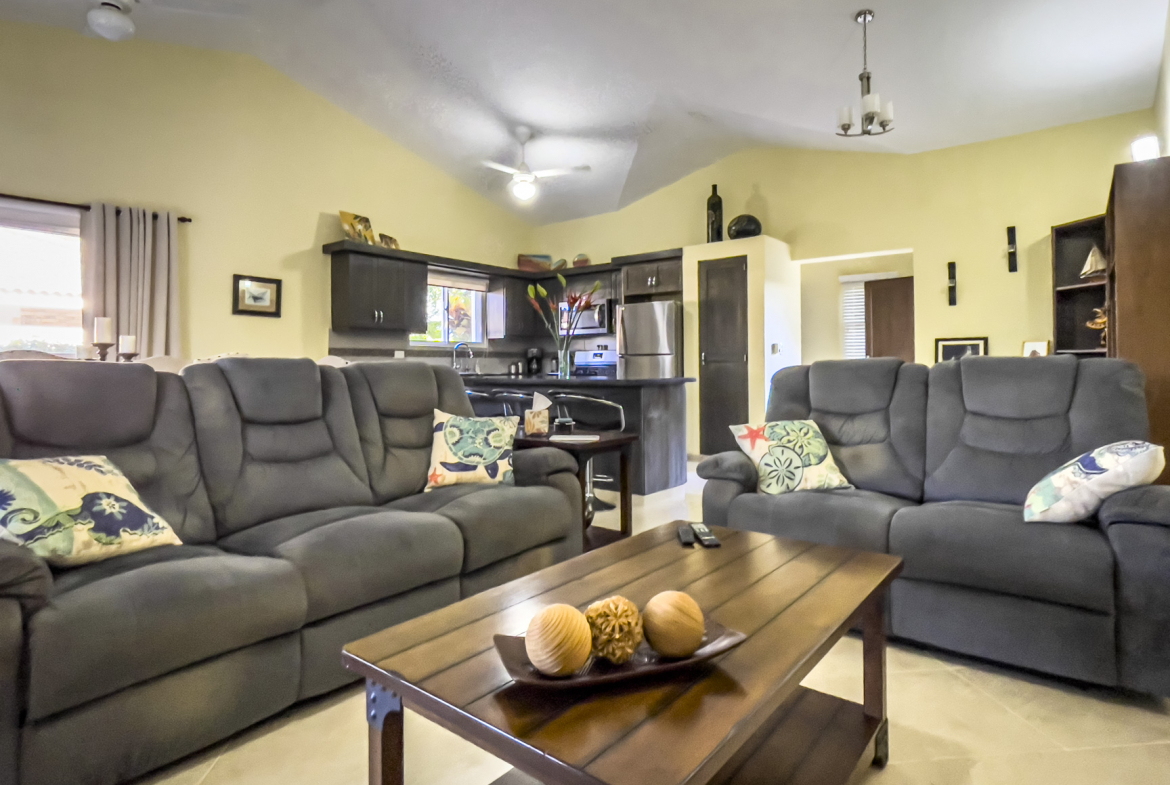 buyDRproperty Living room of a stunning 2 bedroom villa with gray sofas and a wooden coffee table. Sosua Real Estate