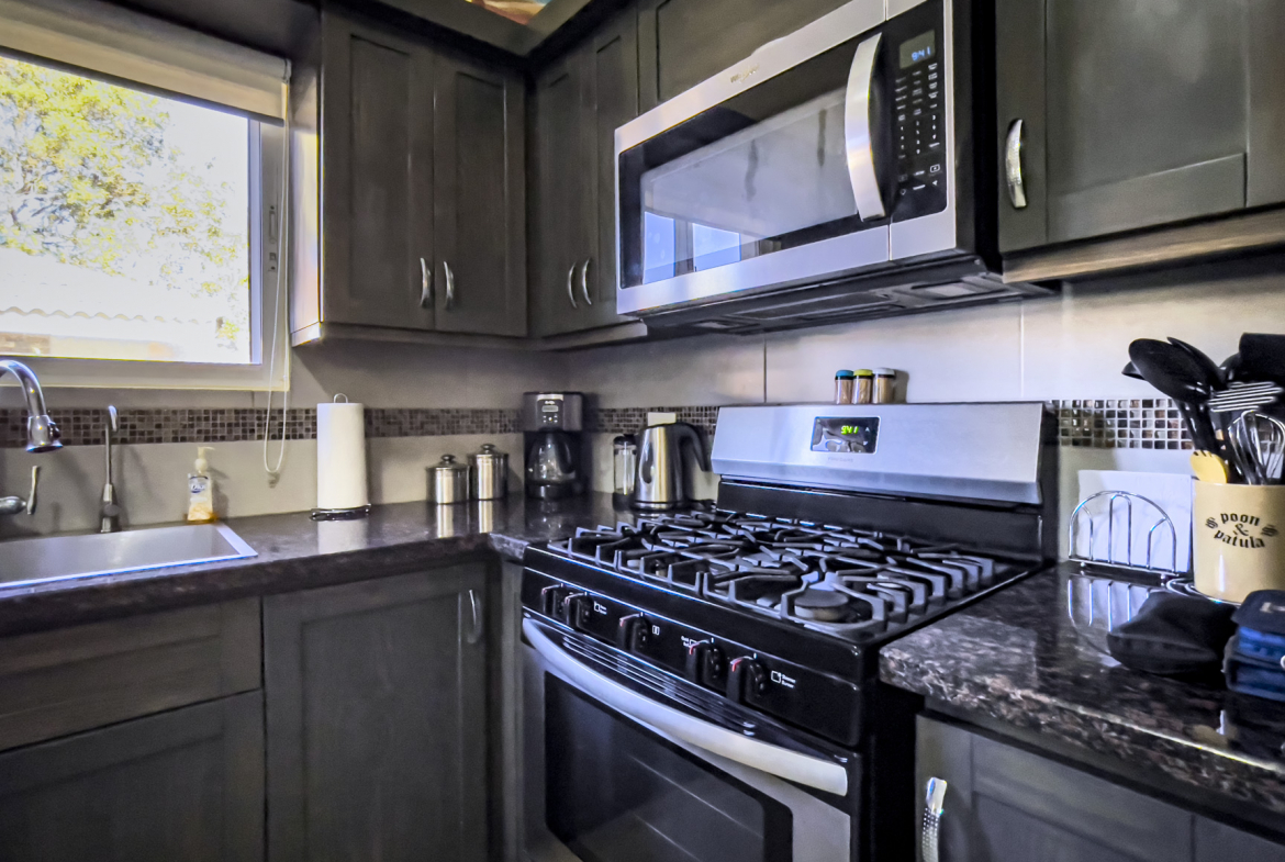 buyDRproperty Kitchen in a stunning 2 bedroom villa with dark cabinets and stainless steel appliances. Sosua Real Estate