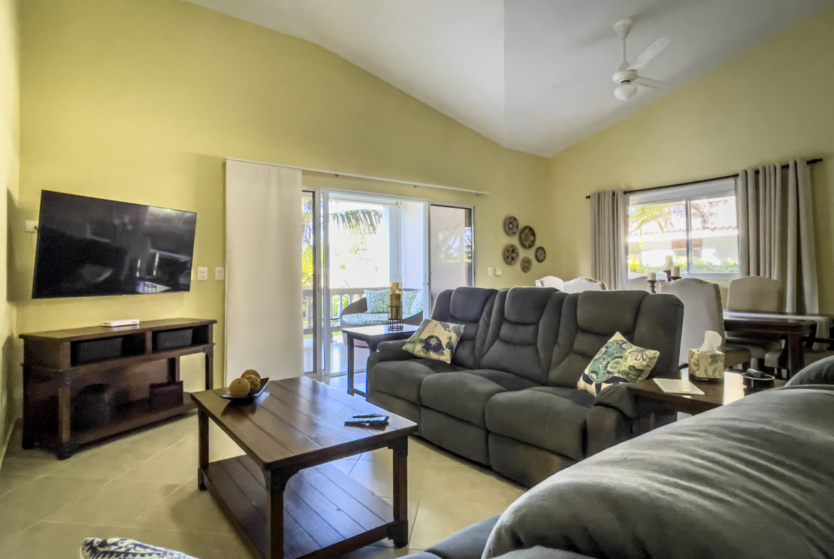 buyDRproperty Living room of a stunning 2 bedroom villa with dark gray sofa and TV. Sosua Real Estate