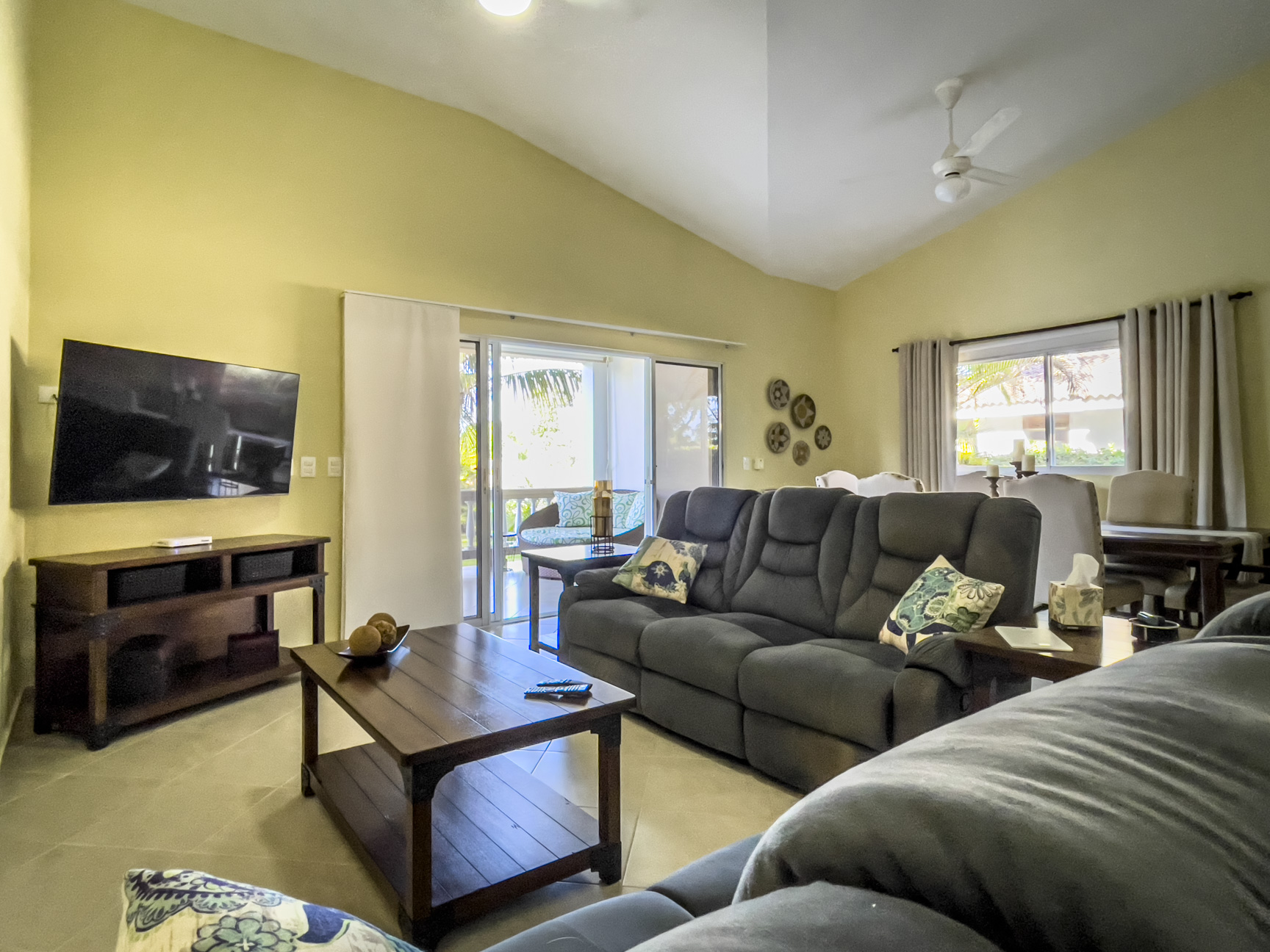 buyDRproperty Living room of a stunning 2 bedroom villa with dark gray sofa and TV. Sosua Real Estate
