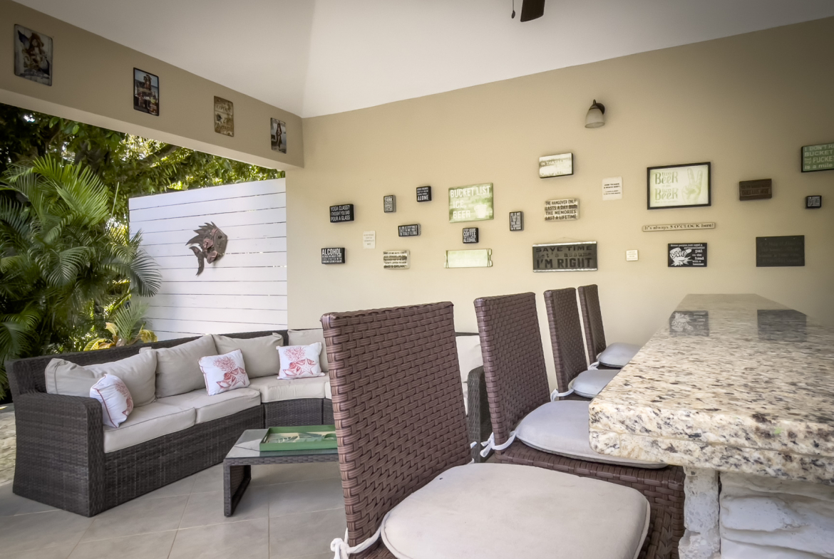 buyDRproperty Outdoor bar area with seating and decorative wall signs in a Stunning 2 Bedroom Villa Sosua Real Estate