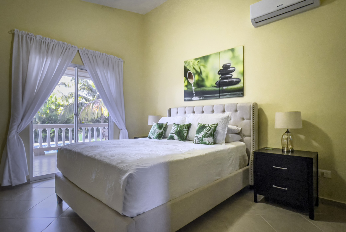 buyDRproperty Stunning 2 Bedroom Villa bedroom with a large bed and tropical decor. Sosua Real Estate