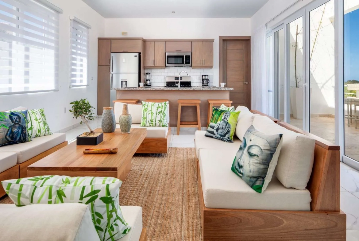 buyDRproperty Villa Seashell Casa Linda: Living room with Buddha pillows, bamboo accents, and kitchen. Sosua Real Estate