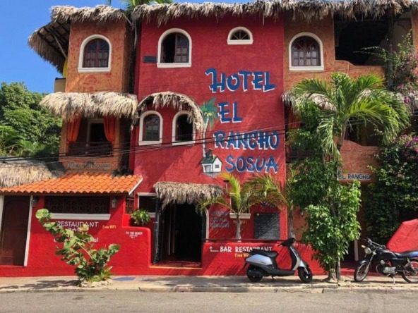 buyDRproperty Hotel El Rancho Sosua, a colorful hotel and restaurant with scooter parked outside. Sosua Real Estate