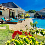 Buydrproperty Two Women Relaxing on Sun Loungers at a Beautiful 9 bedroom Villa with a Pool Sosua Real Estate Buydrpropertycom Buydrpropertycom