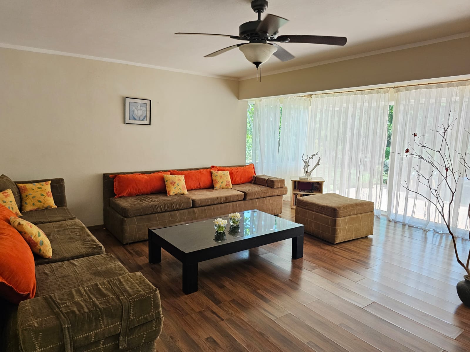 buyDRproperty Living room with brown sofas, orange pillows, and a black coffee table in a Unique Sosua villa. Sosua Real Estate