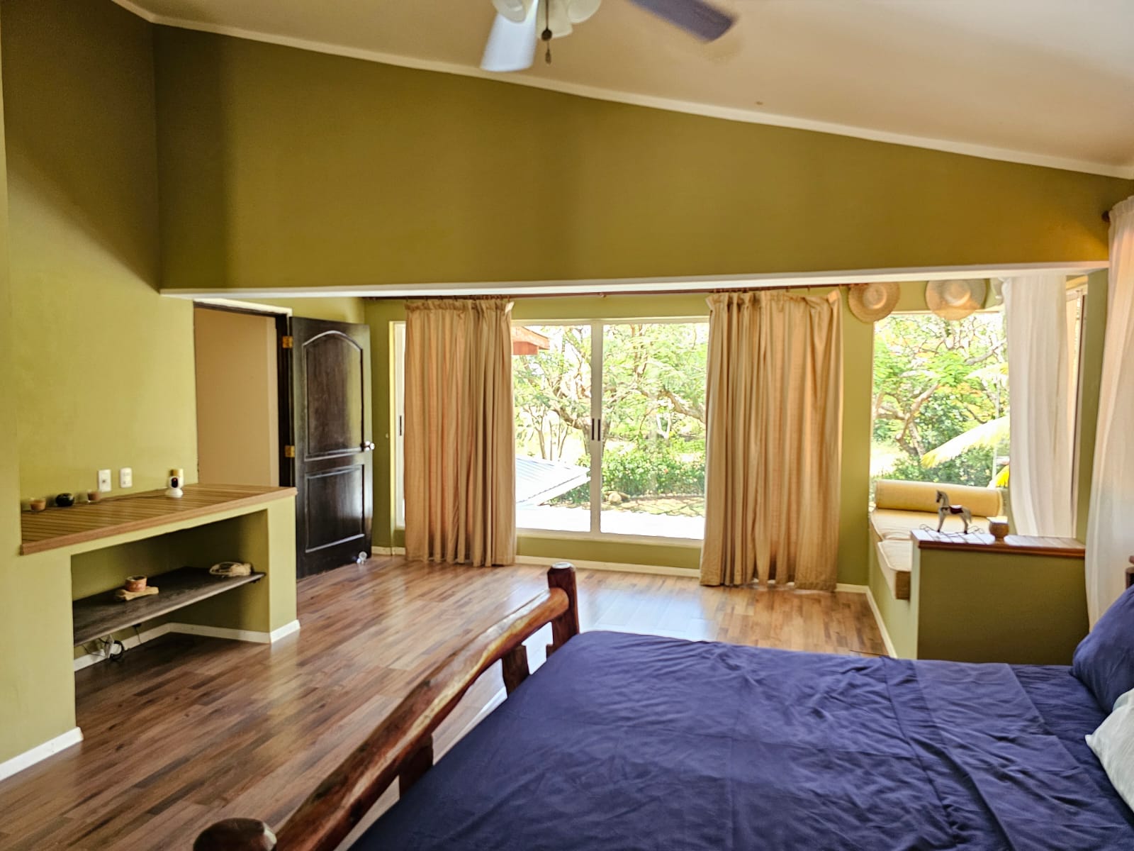 buyDRproperty Spacious bedroom with a large window showcasing beautiful outdoor views, part of a unique villa. Sosua Real Estate