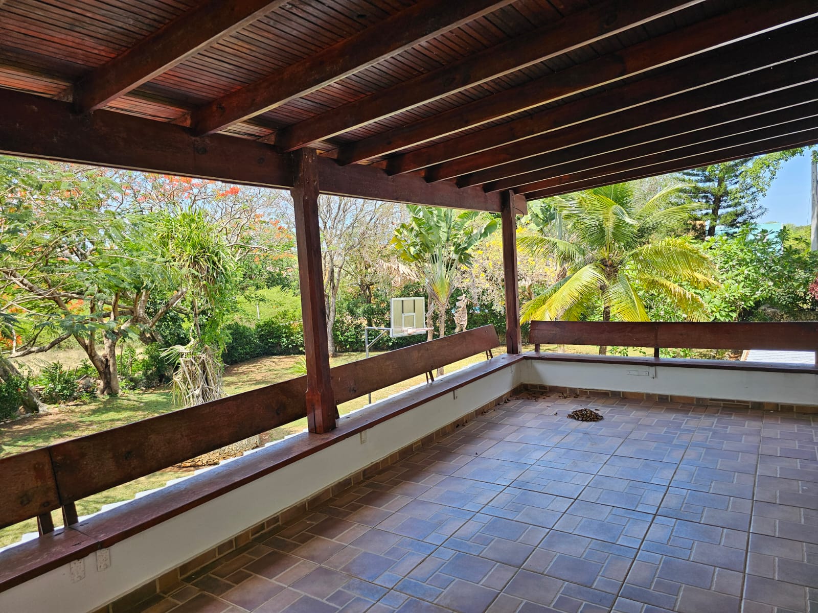 buyDRproperty Sosua villa balcony with wooden beams and lush garden view. Unique property. Sosua Real Estate
