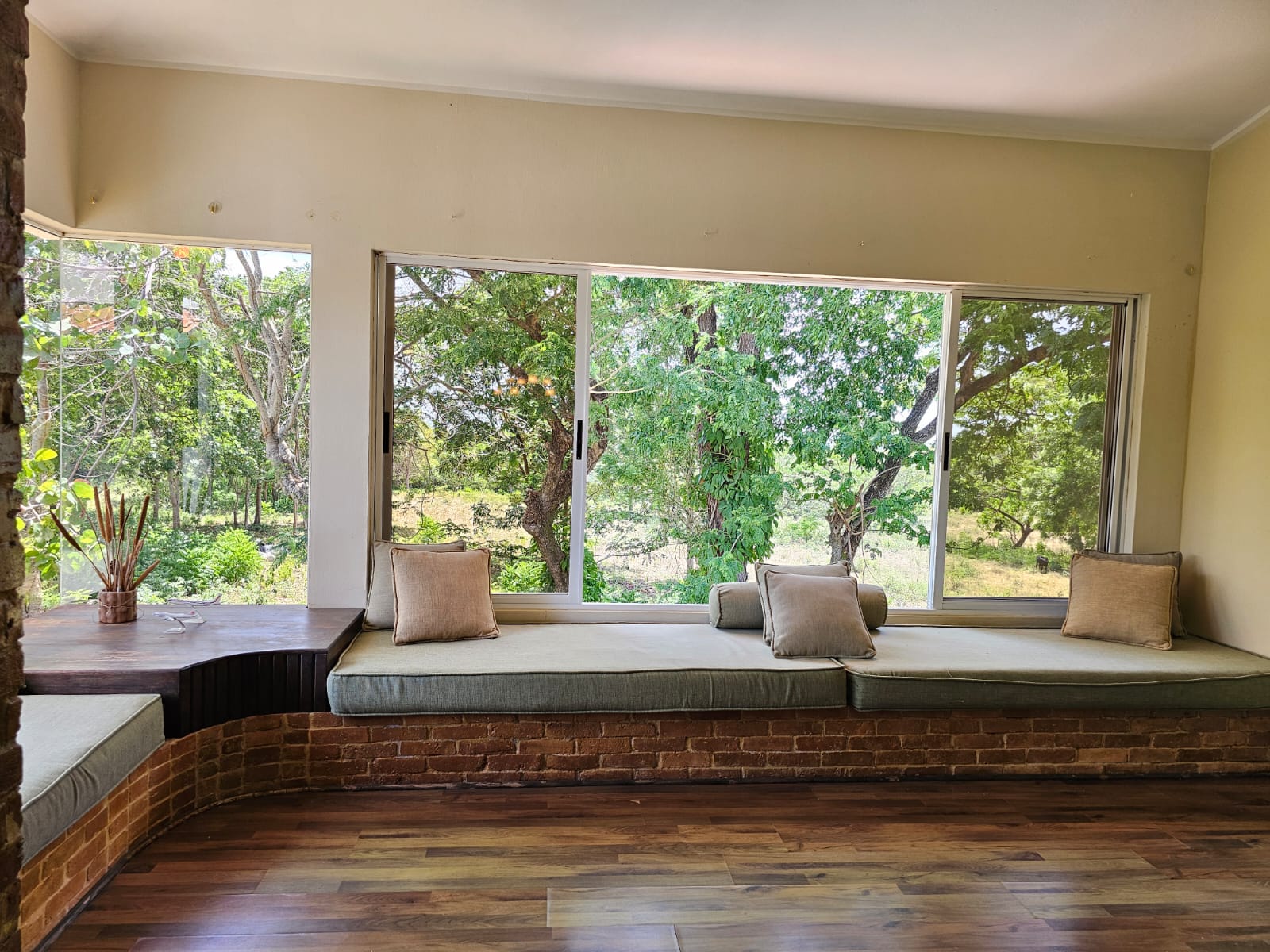 buyDRproperty Cozy window seat with cushions in a unique villa overlooking lush greenery. Sosua Real Estate