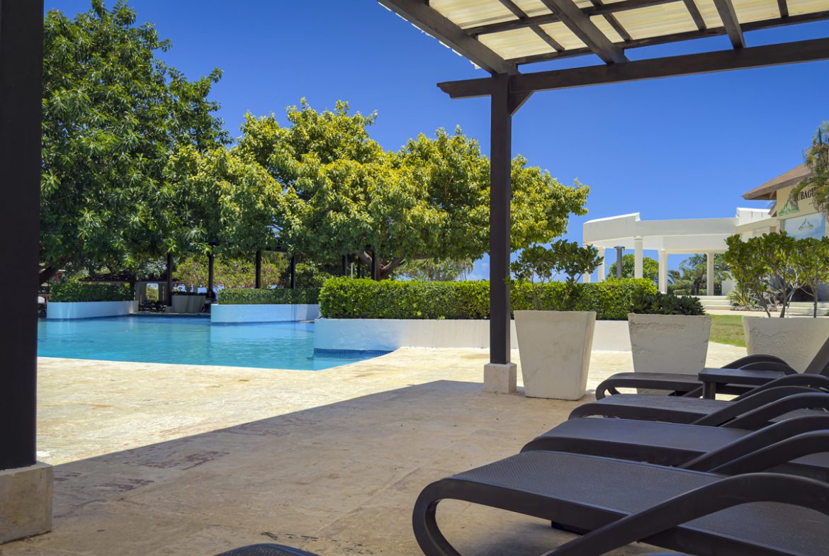 buyDRproperty Luxury pool area with lounge chairs at a villa in Sosua Ocean Village. Sosua Real Estate