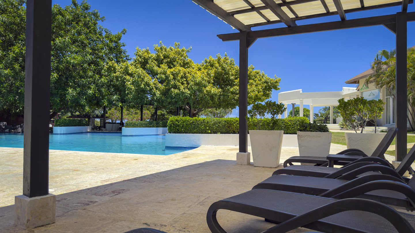 buyDRproperty Luxury pool area with lounge chairs at a villa in Sosua Ocean Village. Sosua Real Estate