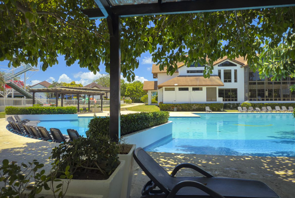 buyDRproperty Pool at Beautiful Modern 3BR Villa Sosua Ocean Village with lounge chairs and greenery. Sosua Real Estate