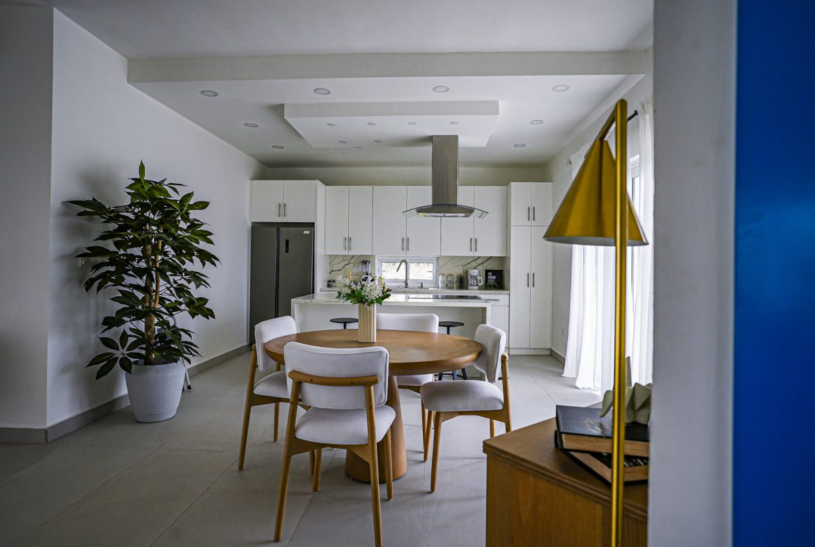 buyDRproperty Modern dining area in a 3 BR villa with white cabinets and round table Sosua Real Estate