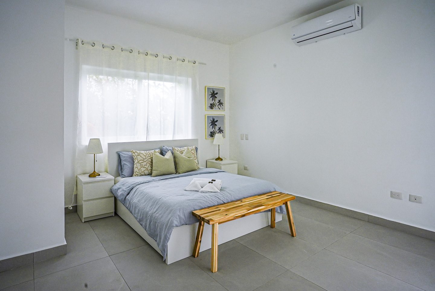 buyDRproperty Modern bedroom in a Sosua Ocean Village villa with bed, nightstands, and bench. Sosua Real Estate