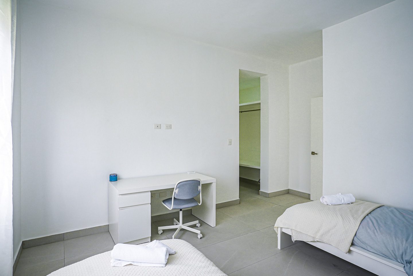 buyDRproperty Modern bedroom with desk, two beds, and closet access. Sosua Real Estate