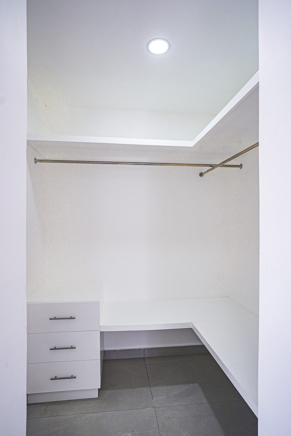 buyDRproperty Modern white closet with drawers and hanging rods in a villa. Sosua Real Estate