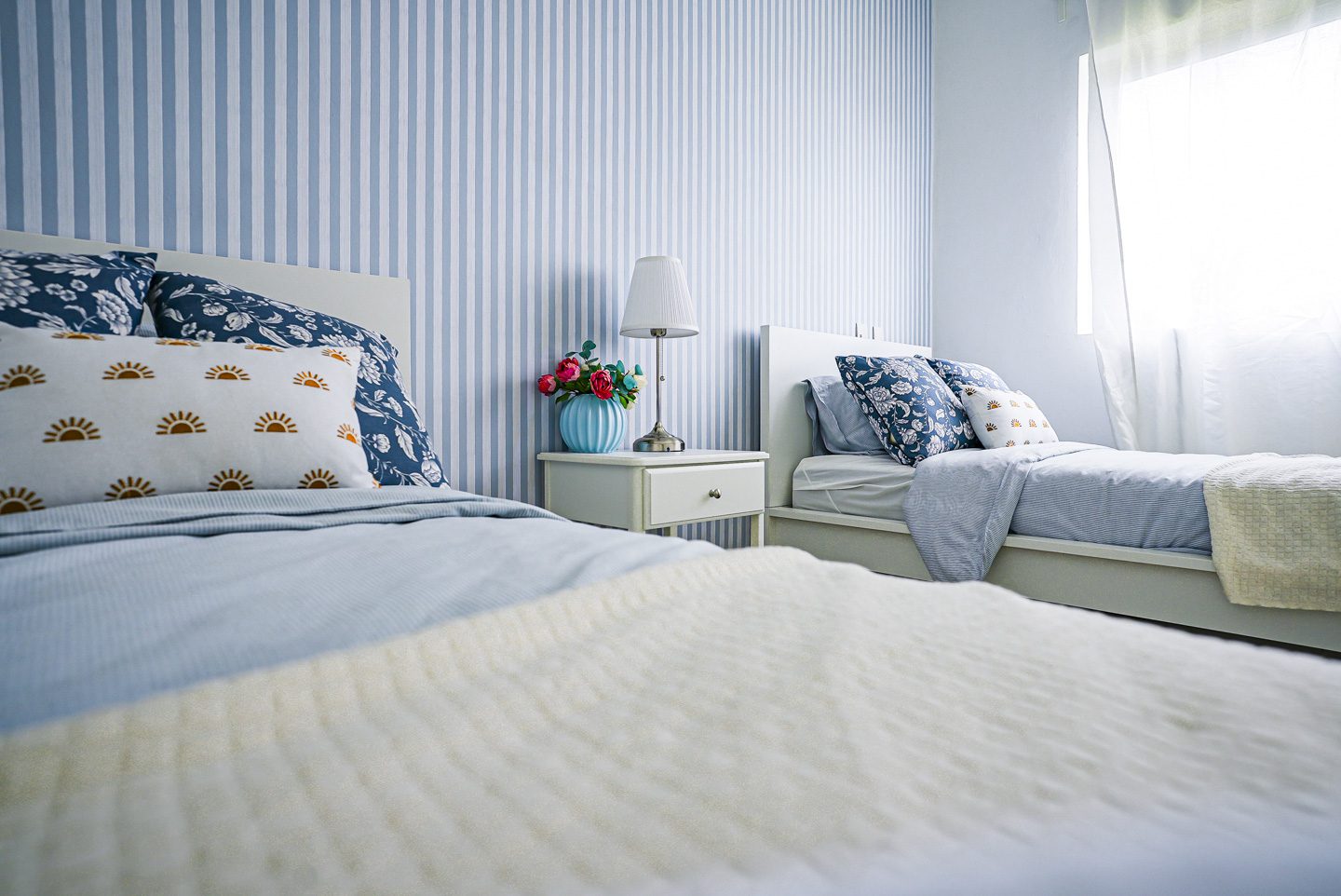 buyDRproperty Modern bedroom with blue and white striped wallpaper and two white beds Sosua Real Estate
