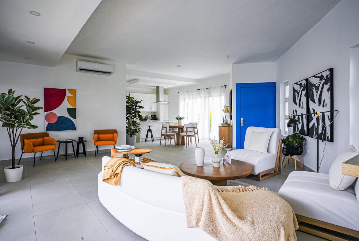 buyDRproperty Modern living room in a 3 BR Villa in Sosua Ocean Village with white furniture and a pop of blue Sosua Real Estate