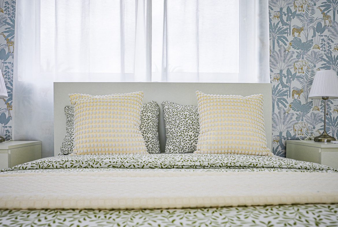 buyDRproperty Modern bedroom with patterned pillows and wallpaper Sosua Real Estate