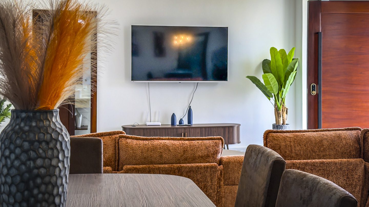 buyDRproperty Modern living room with TV, sofa, and decorative vase in a Sosua villa. Sosua Real Estate