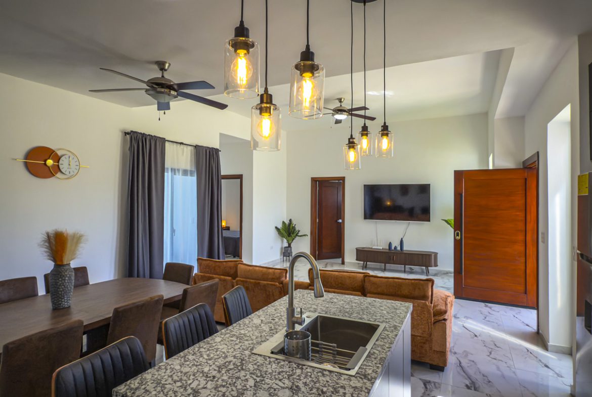 buyDRproperty Modern villa interior with kitchen island, dining area, and living room. Sosua Real Estate