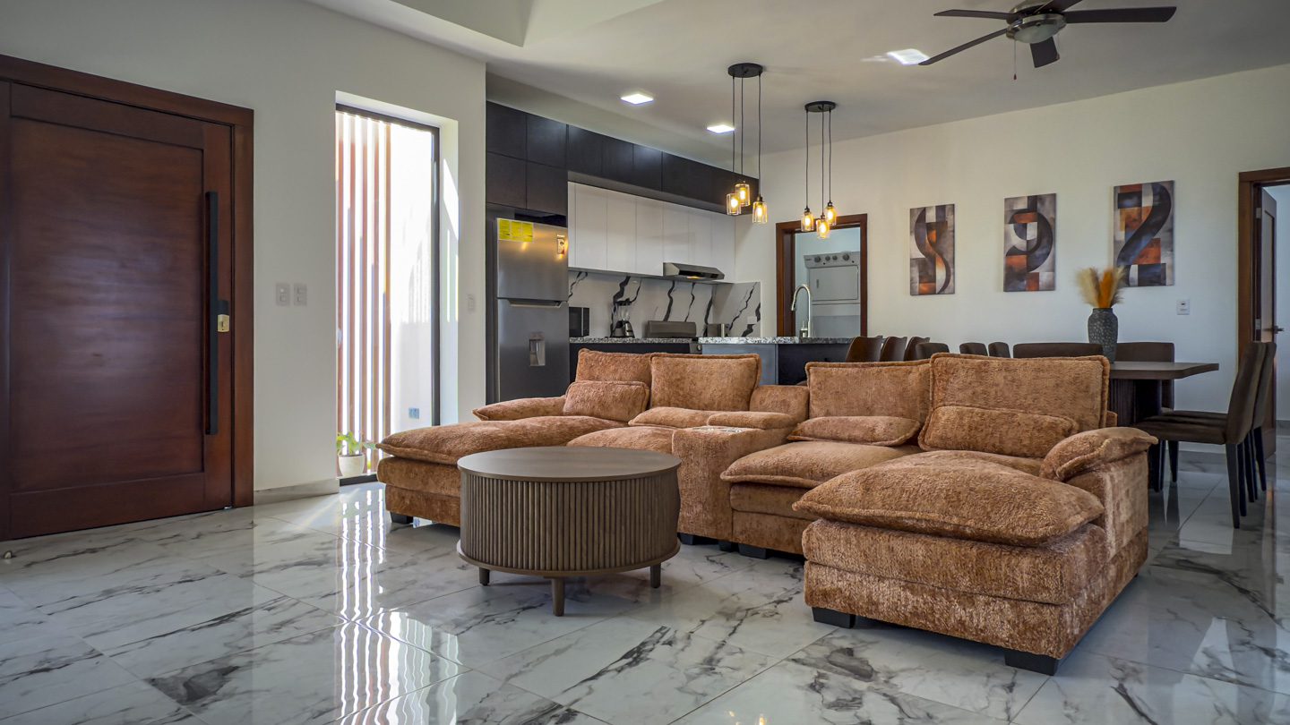 buyDRproperty Modern living room in 3BR Villa Sosua Ocean Village with kitchen, seating and dining area. Sosua Real Estate