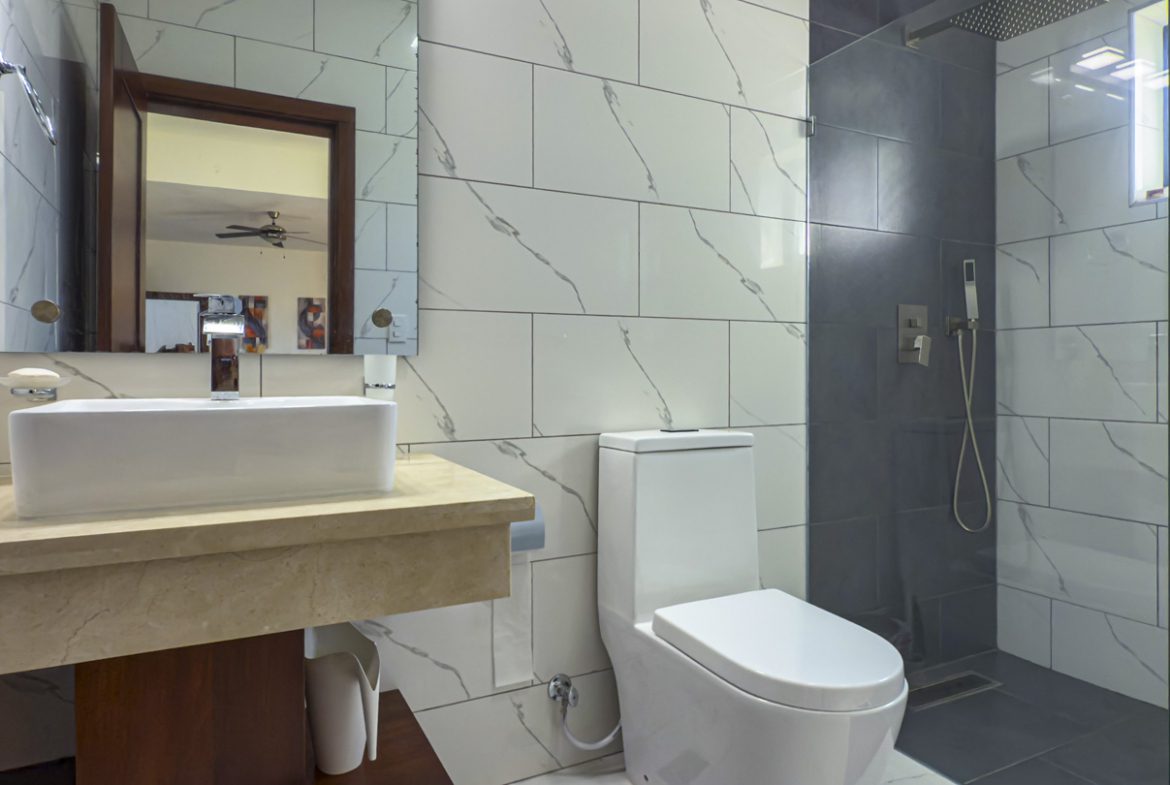 buyDRproperty Modern bathroom in a Sosua Ocean Village villa with marble-look tiles and walk-in shower. Sosua Real Estate