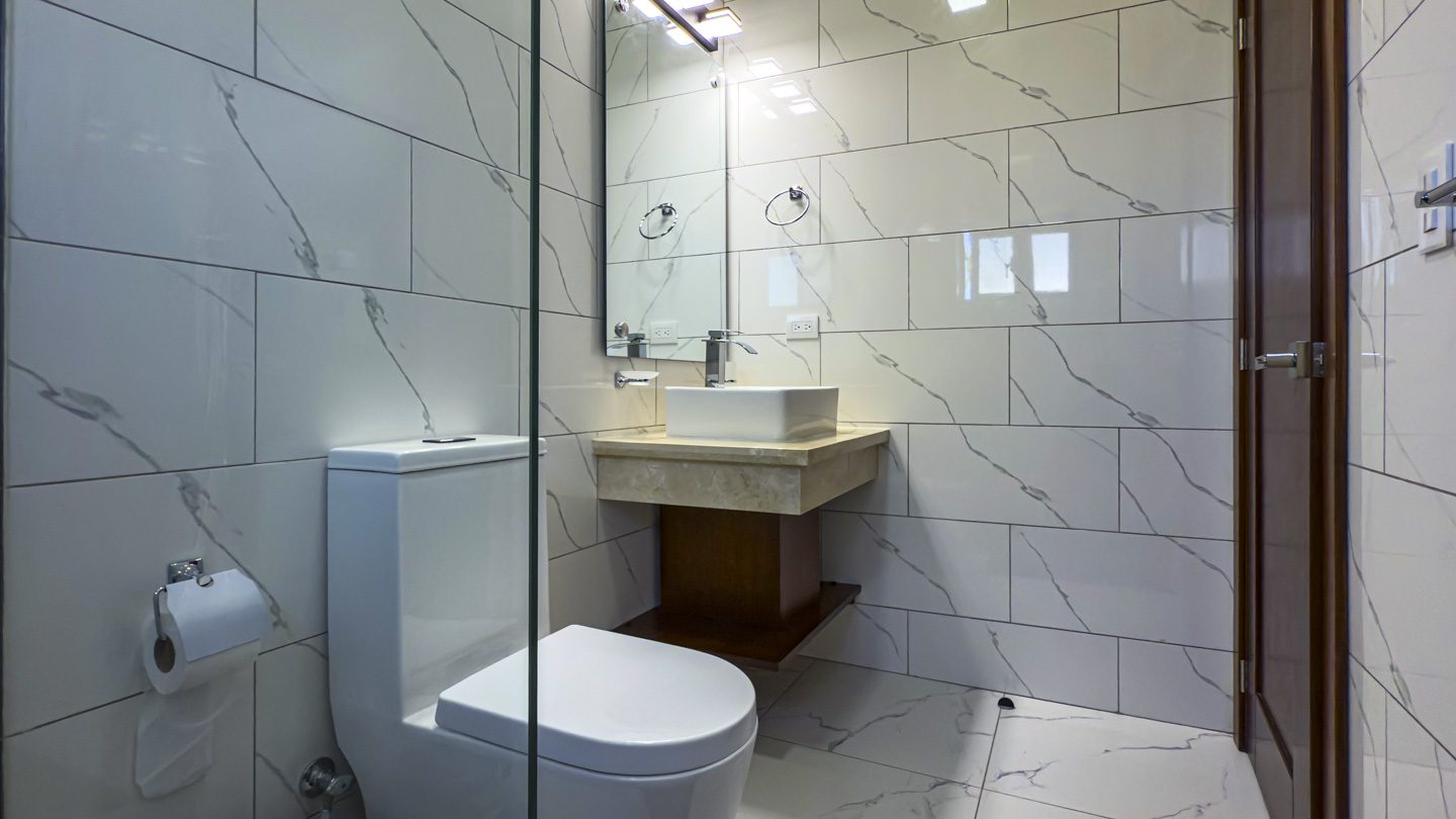 buyDRproperty Modern bathroom with marble tile, square sink, and toilet Sosua Real Estate