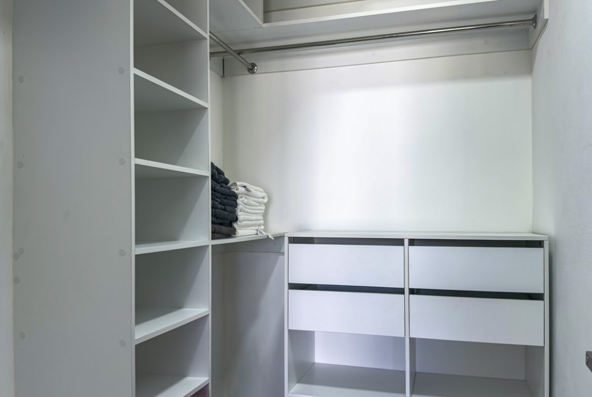 buyDRproperty Modern walk-in closet with white shelves and drawers, clean and organized. Sosua Real Estate