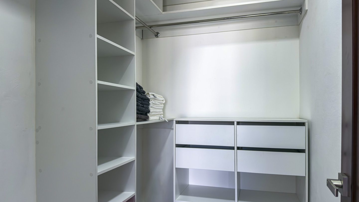 buyDRproperty Modern walk-in closet with white shelves and drawers, clean and organized. Sosua Real Estate
