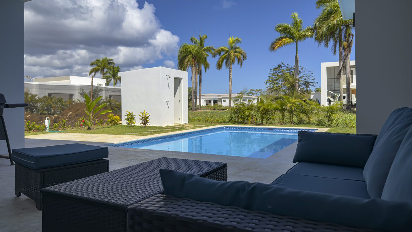 buyDRproperty Modern villa patio with pool, Sosua Ocean Village, palm trees and outdoor seating. Sosua Real Estate
