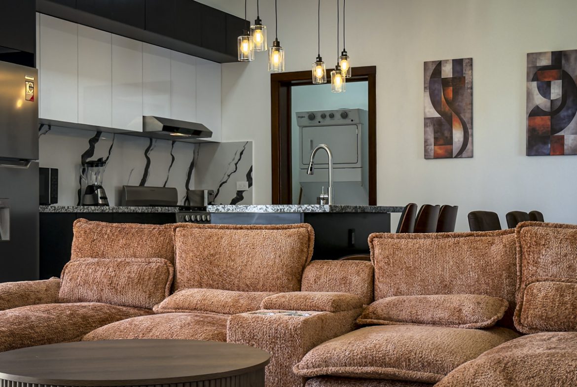 buyDRproperty Modern kitchen and living area with brown sofa, part of a 3BR Villa in Sosua Ocean Village. Sosua Real Estate