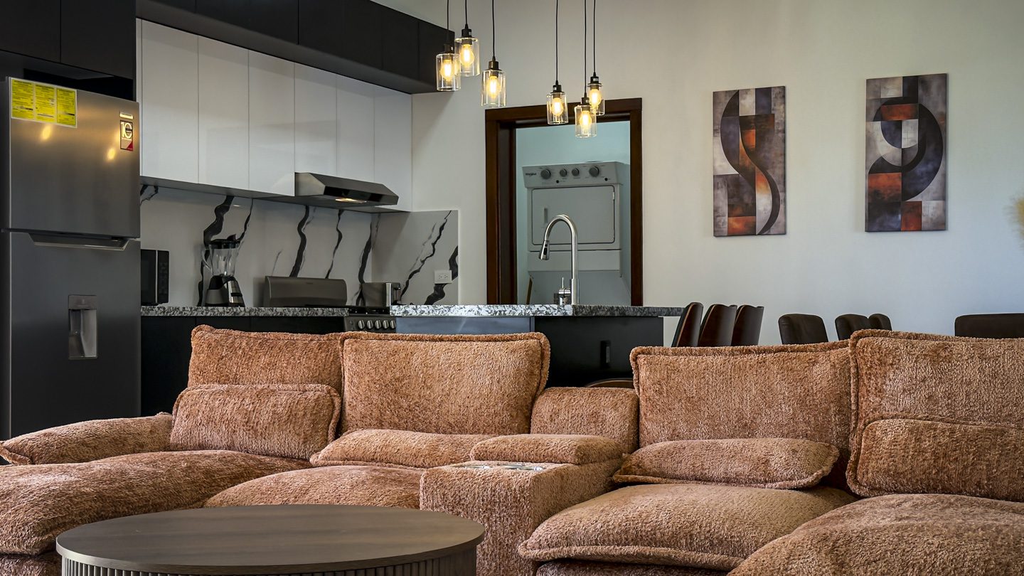 buyDRproperty Modern kitchen and living area with brown sofa, part of a 3BR Villa in Sosua Ocean Village. Sosua Real Estate