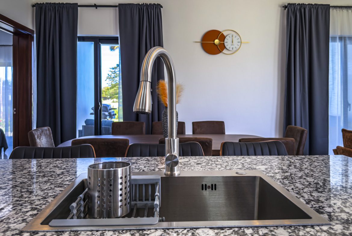 buyDRproperty Modern kitchen with stainless steel sink and granite countertop in a villa. Sosua Real Estate