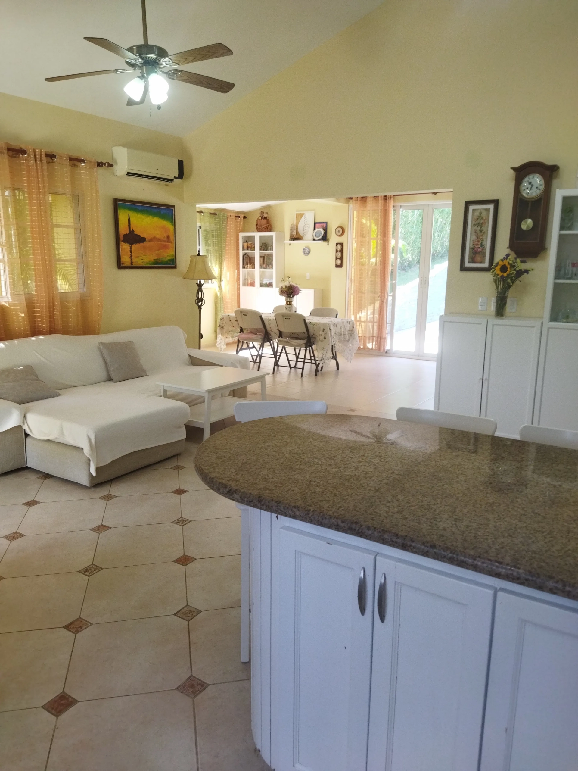 buyDRproperty Charming interior of a villa with white sofa, kitchen island, and dining area. Sosua Real Estate