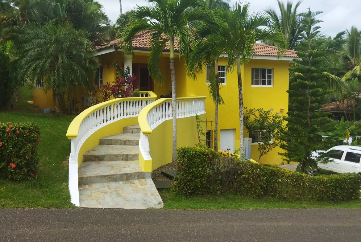 buyDRproperty Charming yellow villa with curved staircase and palm trees. Sosua Real Estate