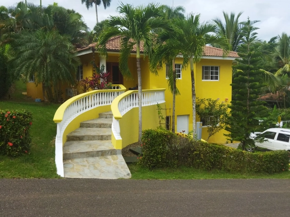 yellow villa with stairs to the entrance