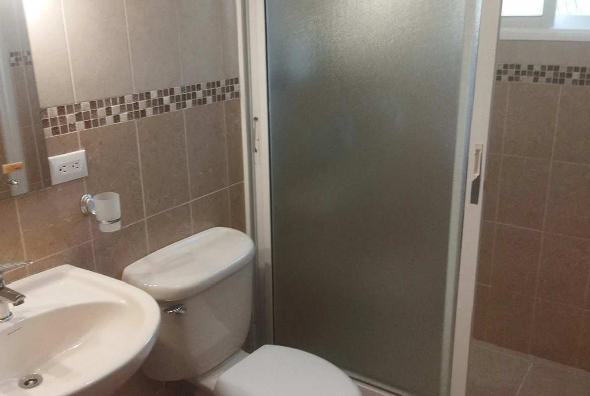 buyDRproperty Charming bathroom with toilet, sink, and shower. Sosua Real Estate