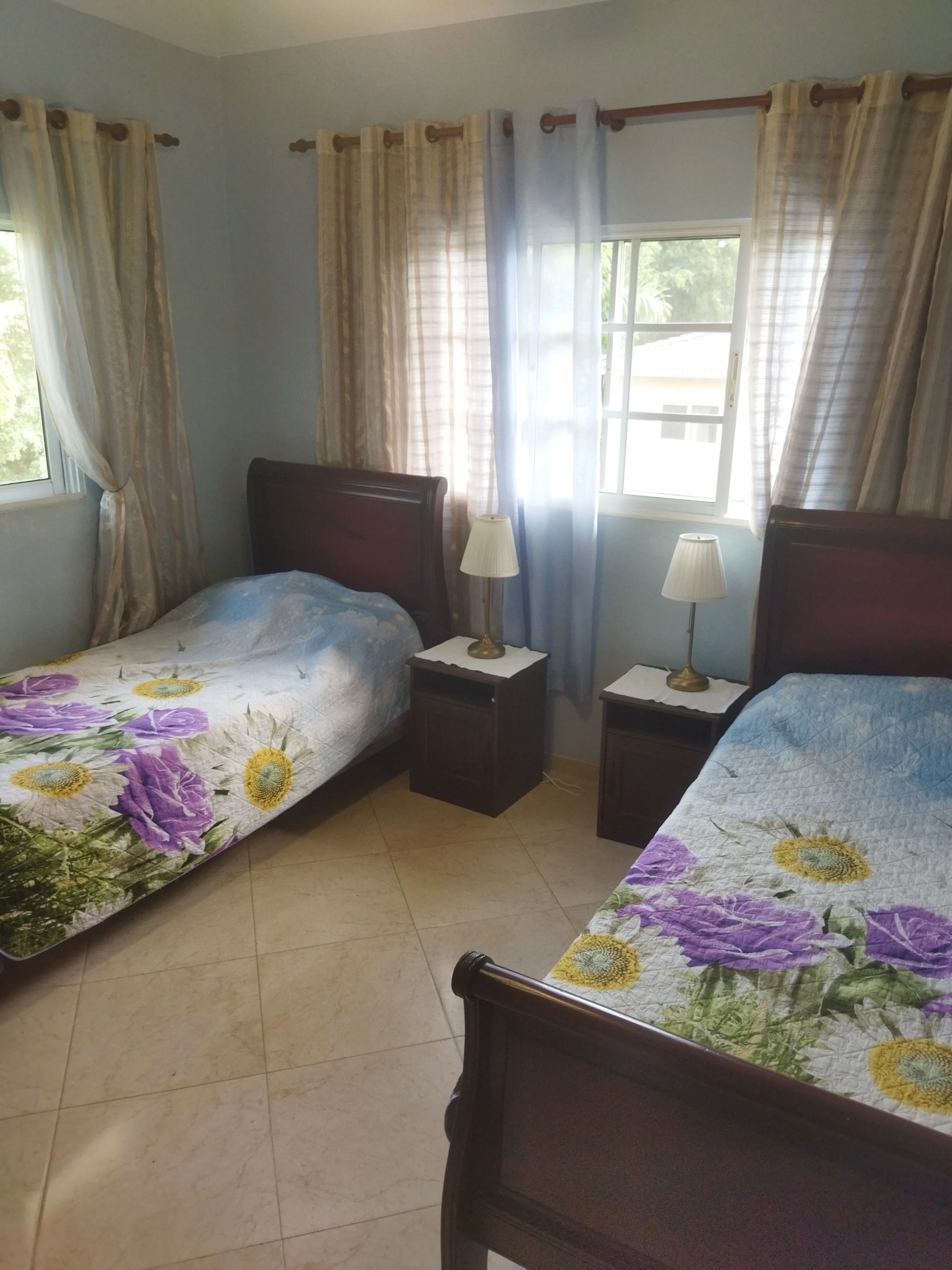 buyDRproperty Charming bedroom with two beds and floral bedspreads. Sosua Real Estate
