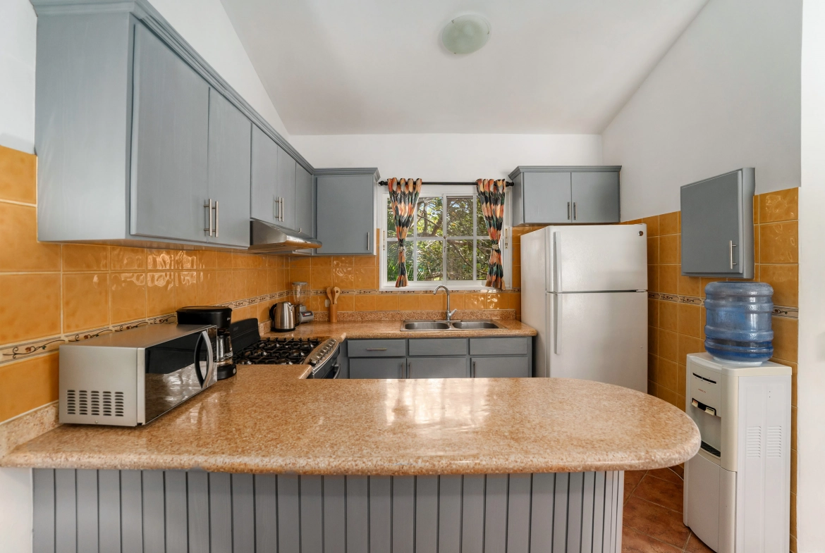 buyDRproperty Gray kitchen cabinets and countertop in a Sosua villa for sale. Sosua Real Estate