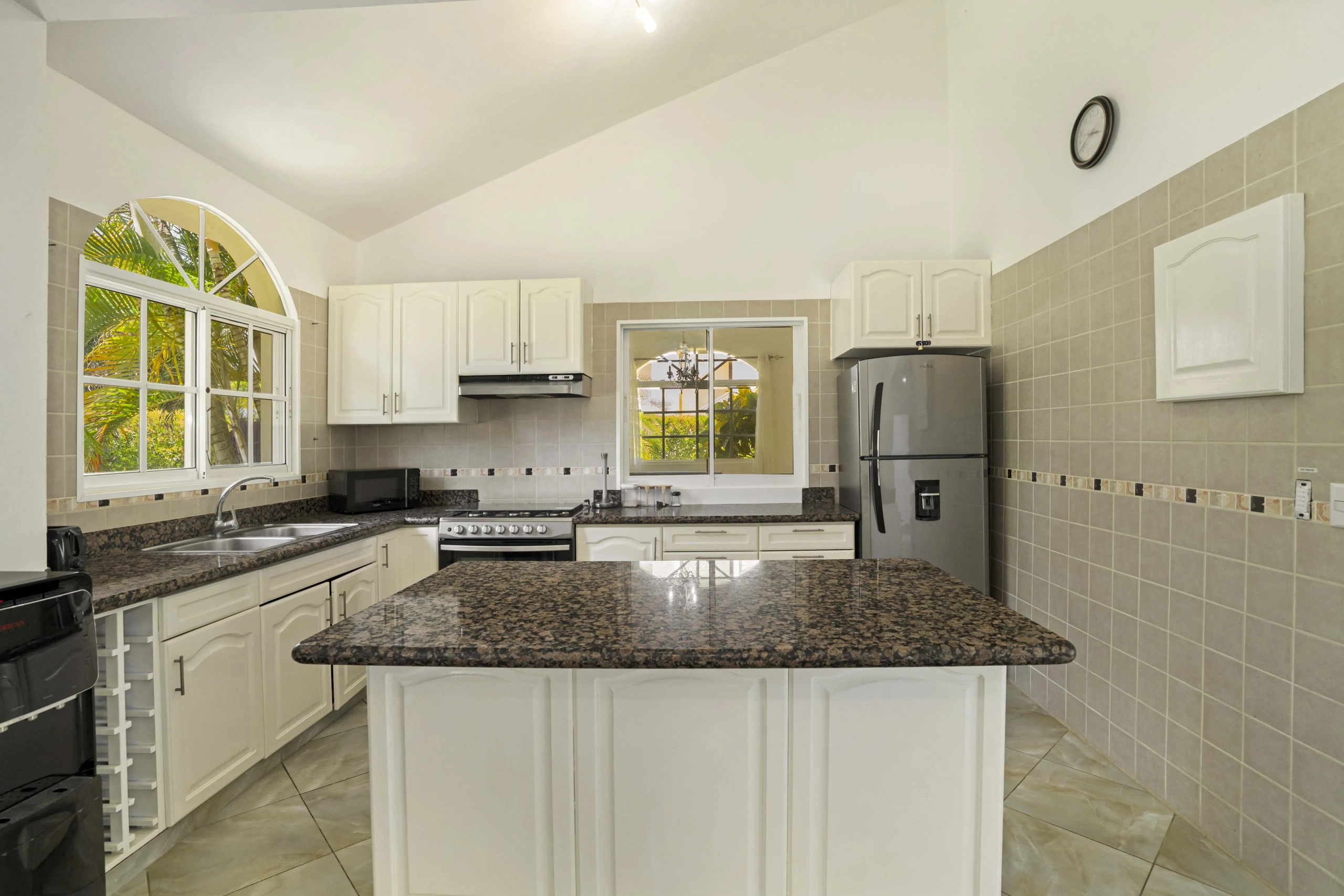 buyDRproperty Beautiful kitchen in the Hispaniola Residencial villa with white cabinets and granite countertops. Sosua Real Estate