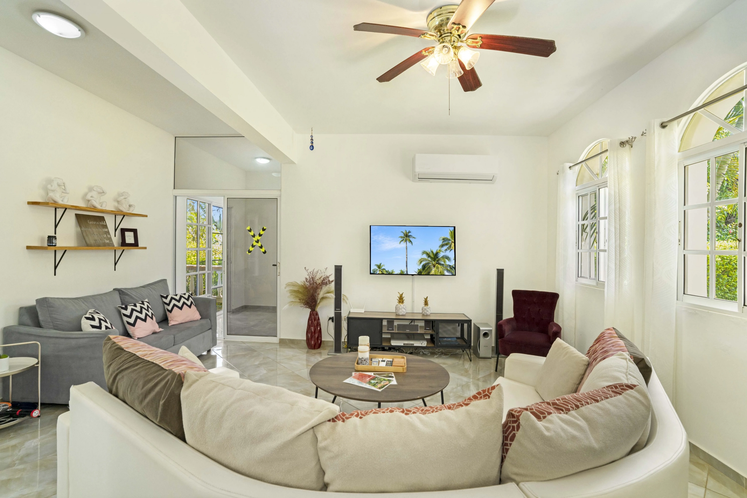 buyDRproperty Beautiful living room in a villa with white sofa, TV, and windows. Sosua Real Estate
