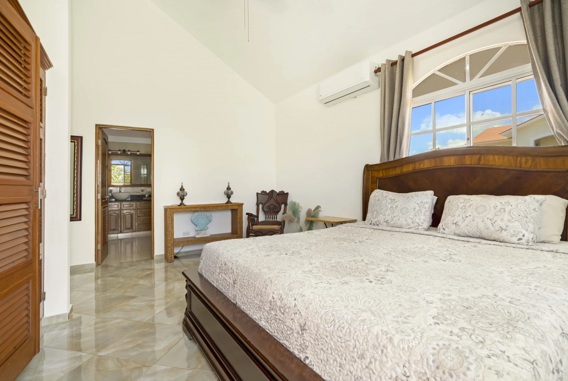 buyDRproperty Beautiful bedroom in a villa with arched window and wooden furniture. Sosua Real Estate