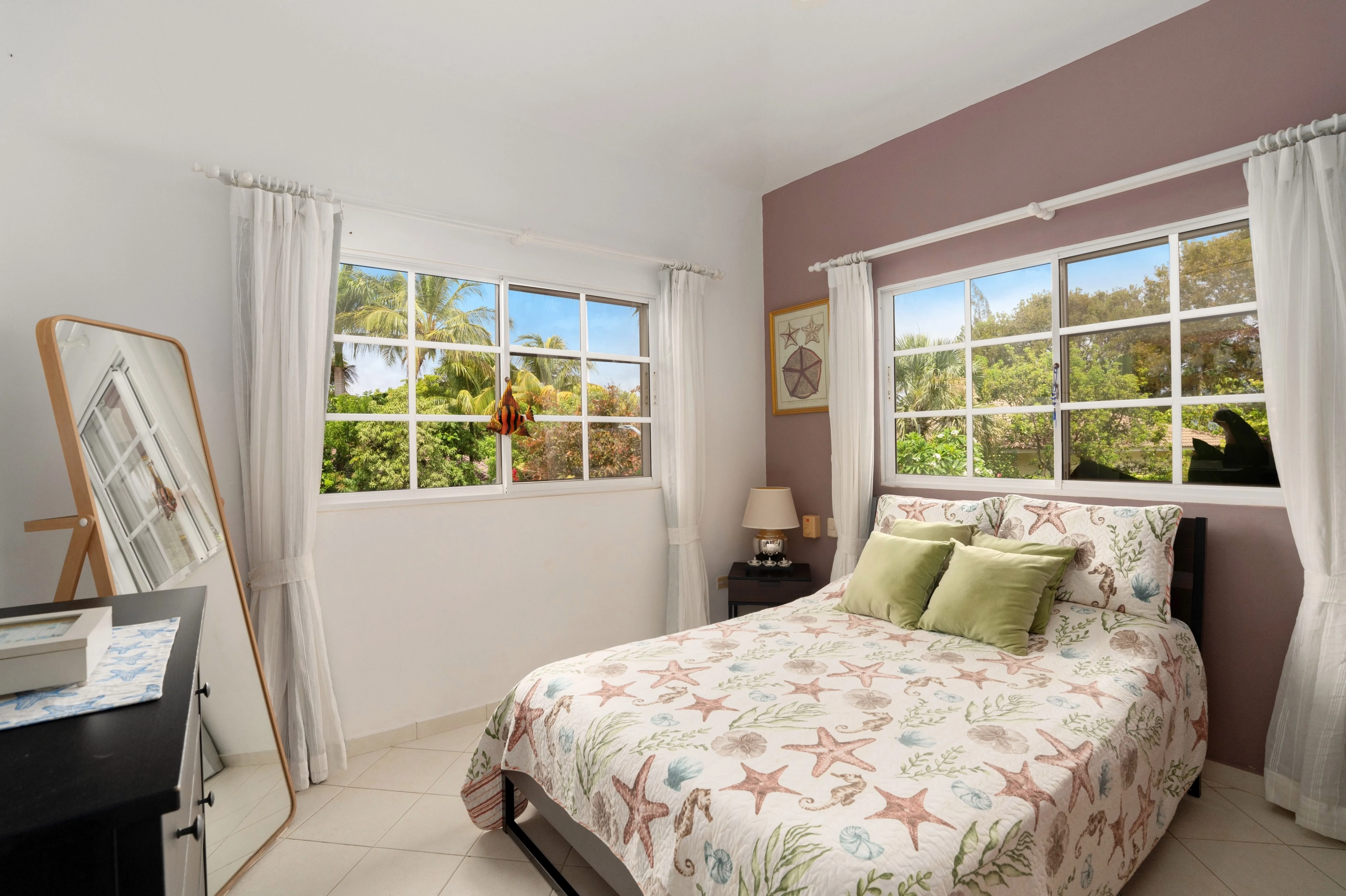buyDRproperty Charming bedroom with coastal decor, bed, and large windows. Sosua Real Estate