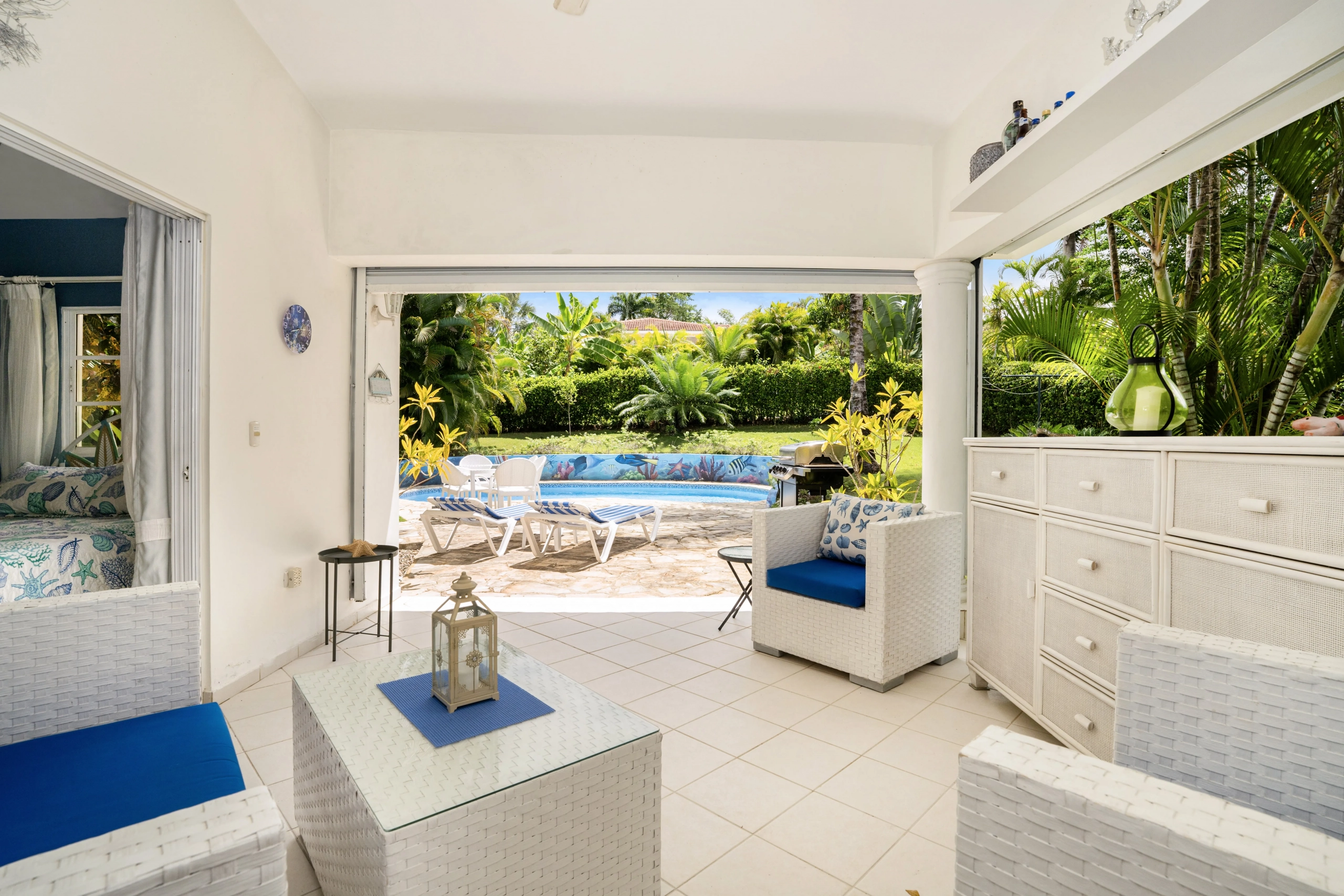 buyDRproperty Charming villa living space with pool view, white wicker furniture Sosua Real Estate