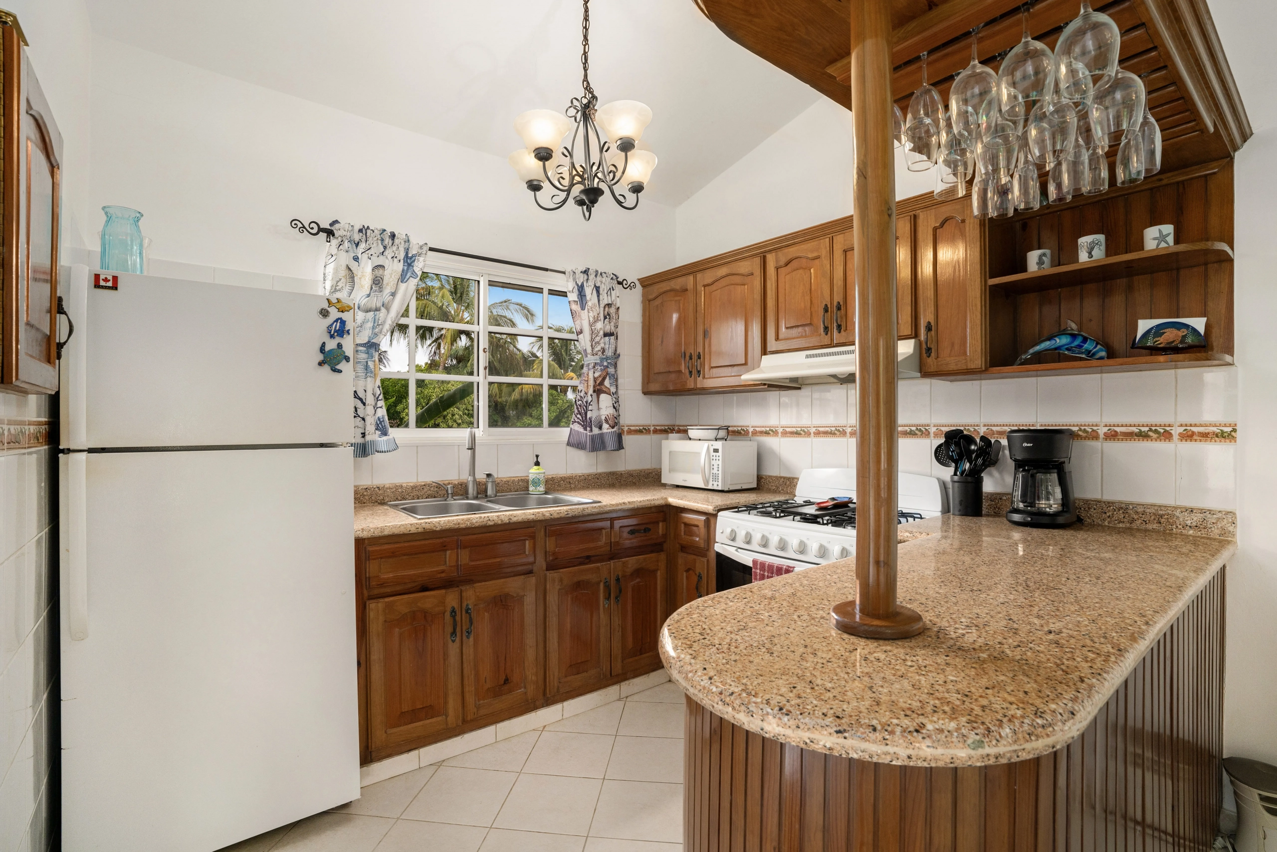buyDRproperty Charming kitchen in a Sosua villa with wooden cabinets, granite countertop, and breakfast bar. Sosua Real Estate