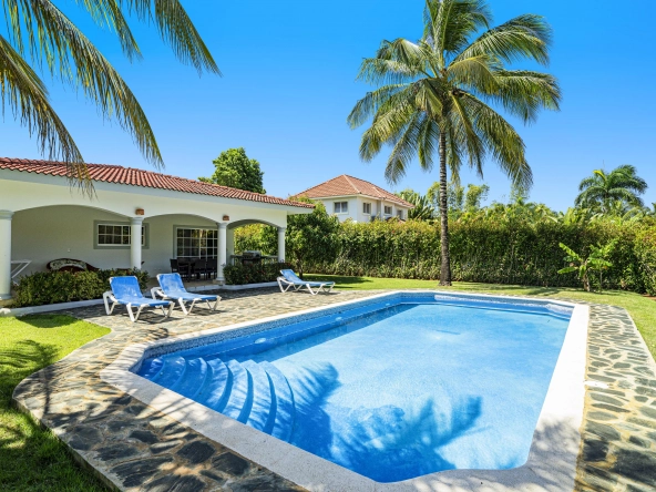 buyDRproperty Oversized villa in Sosua with a pool, lounge chairs, and palm trees. Sosua Real Estate
