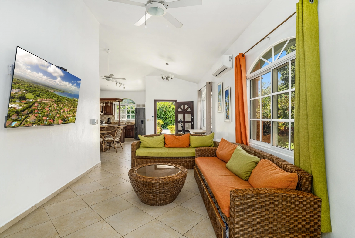 buyDRproperty Spacious, oversized villa living room with wicker furniture and colorful cushions. Sosua Real Estate