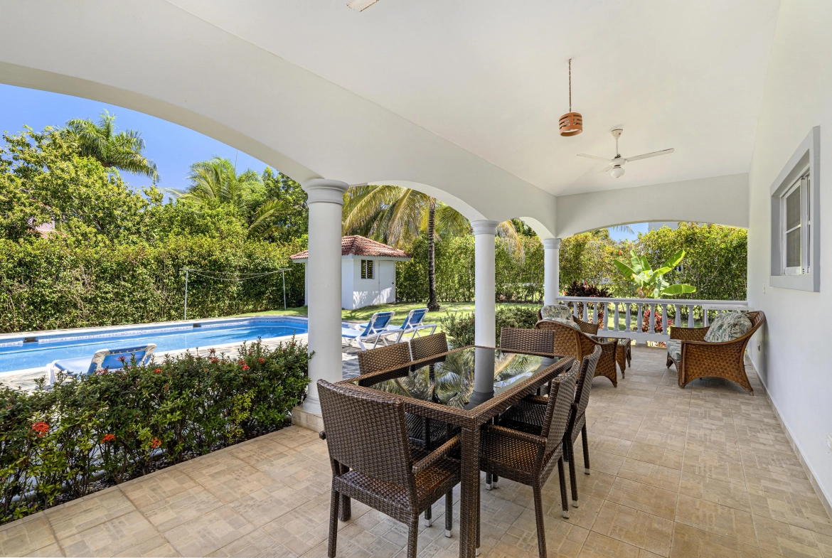 buyDRproperty Oversized patio with outdoor dining set overlooking a pool in a tropical villa. Sosua Real Estate